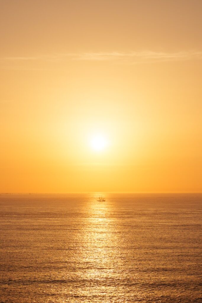 A small boat on the ocean at sunset.